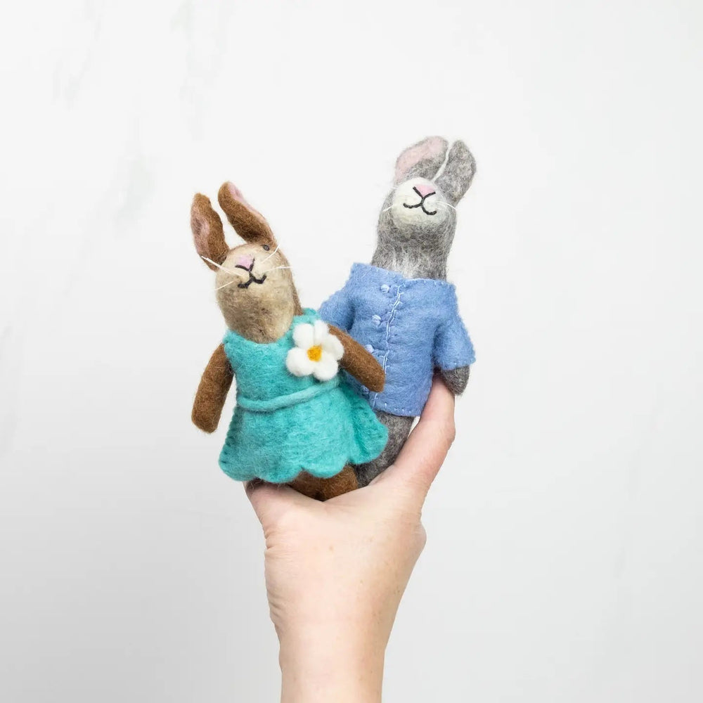 fair trade felt bunnies in blue and teal outfit held in hand by the winding road